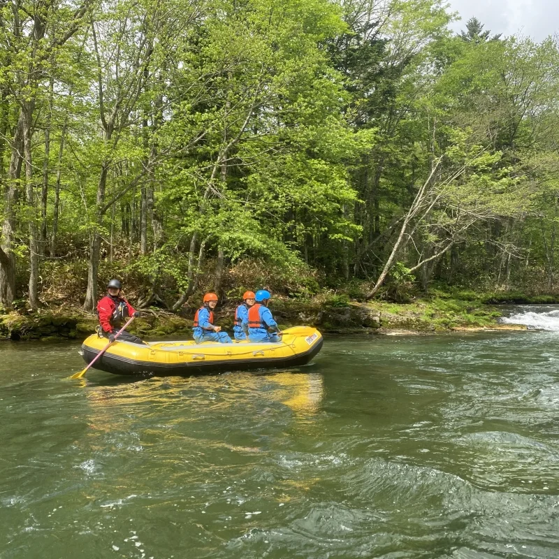 Participants en rafting à Furano avec casques et gilets sur la rivière