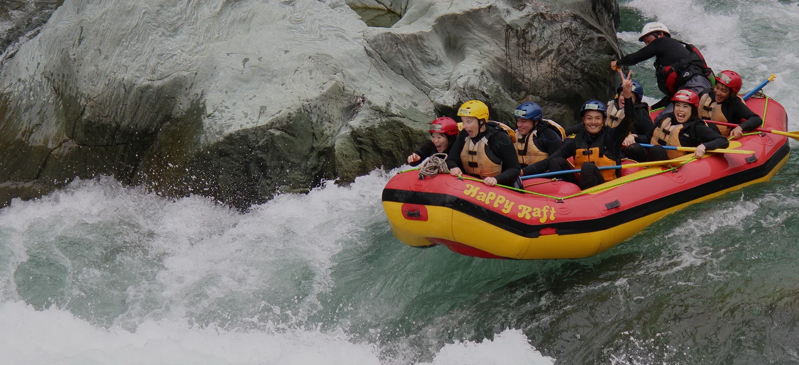Happy Raft participants paddling through white water on the Yoshino River in Shikoku