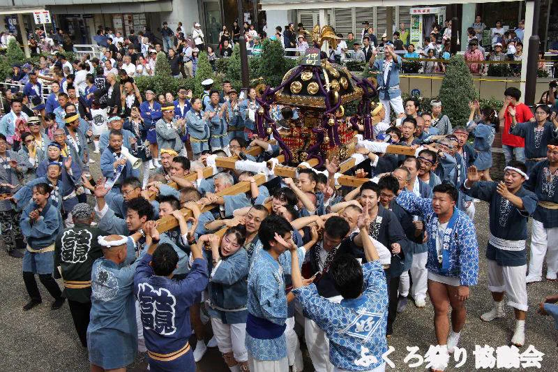 Le mikoshi du festival de Ikebukuro Fukuro défile dans les rues de la ville, les spectateurs regardent depuis les deux côtés de la route.