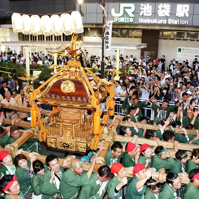 Le grand mikoshi de la fête Fukuro devant la sortie ouest de la gare d'Ikebukuro et la foule de spectateurs.