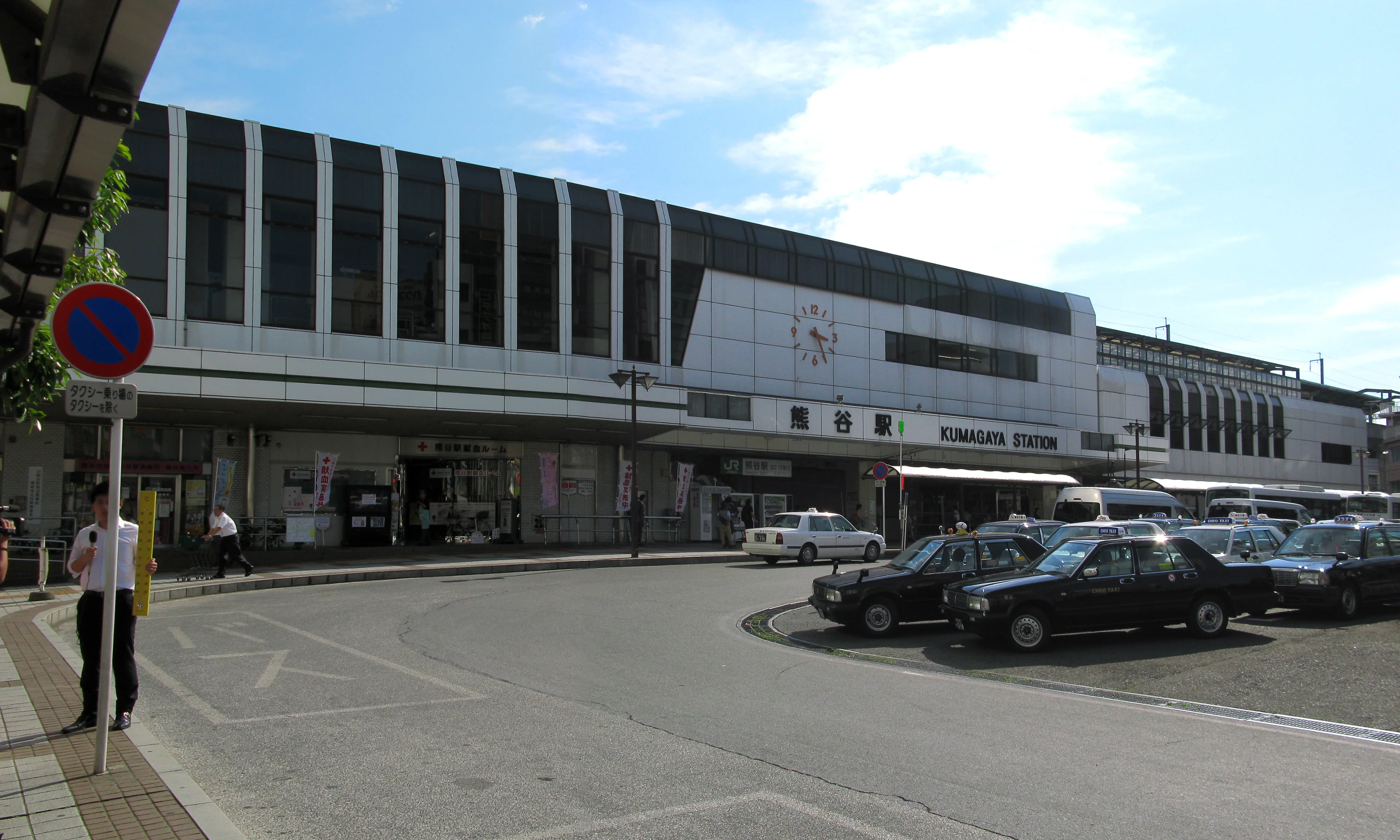 Sortie nord de la gare de Kumagaya, illustrant la foule et la direction du retour après les feux