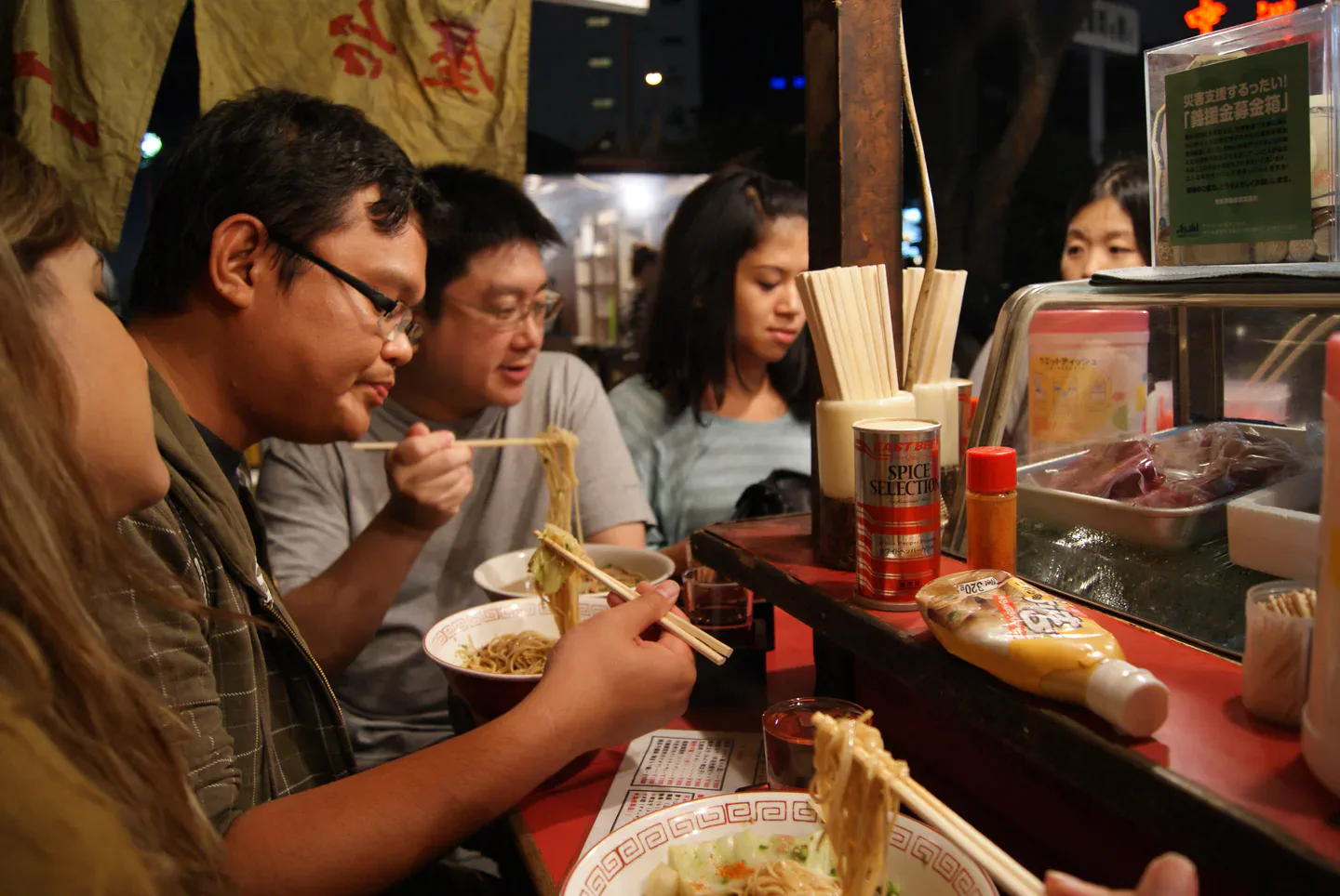 Vue nocturne des stands au bord de la rivière à Nakasu, Fukuoka, et organisation du dîner pour la première soirée