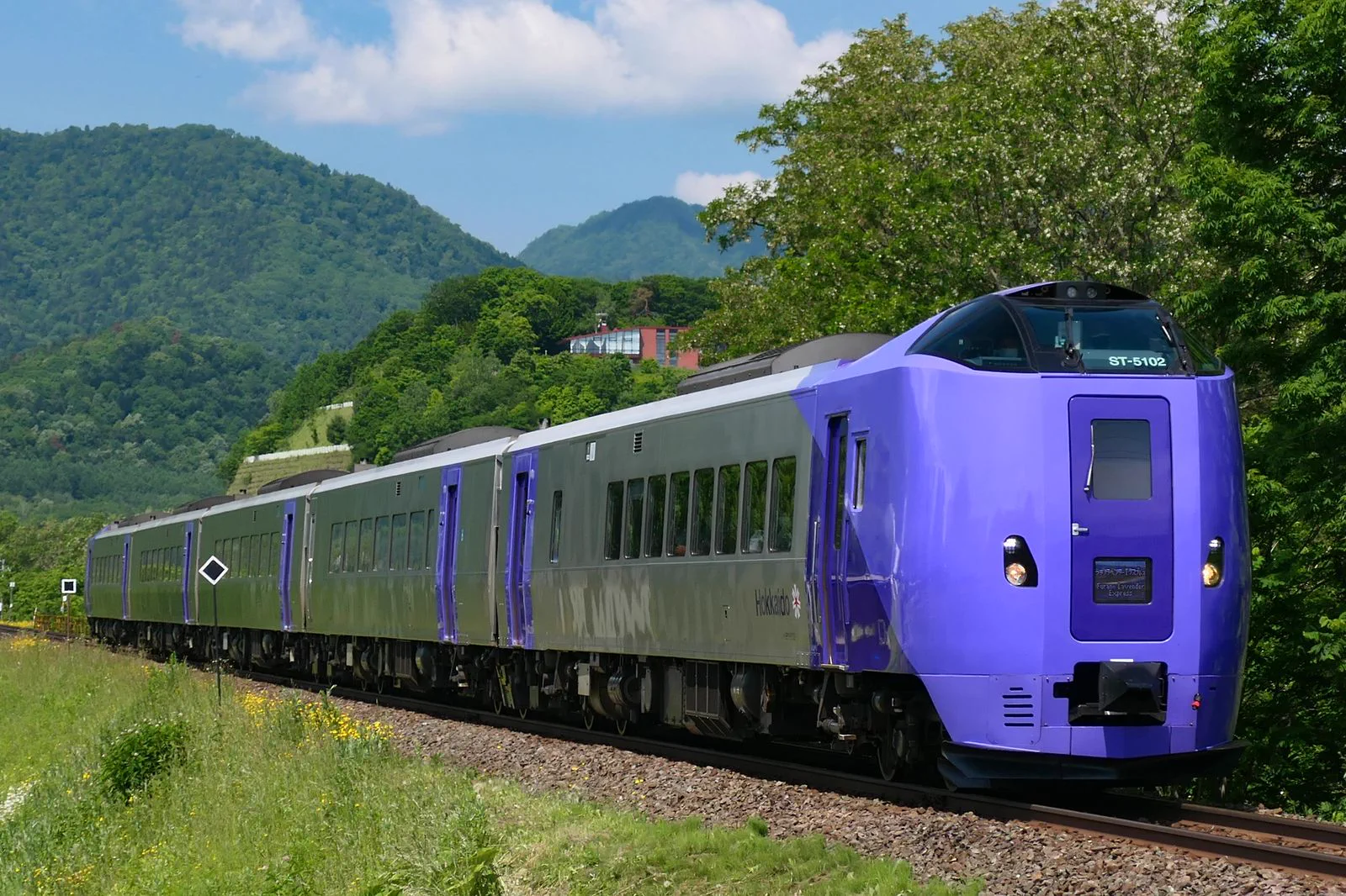 Le train express lavande de Furano circule sur la ligne ferroviaire d'Hokkaido, illustrant la liaison saisonnière entre Sapporo, Asahikawa et Furano.