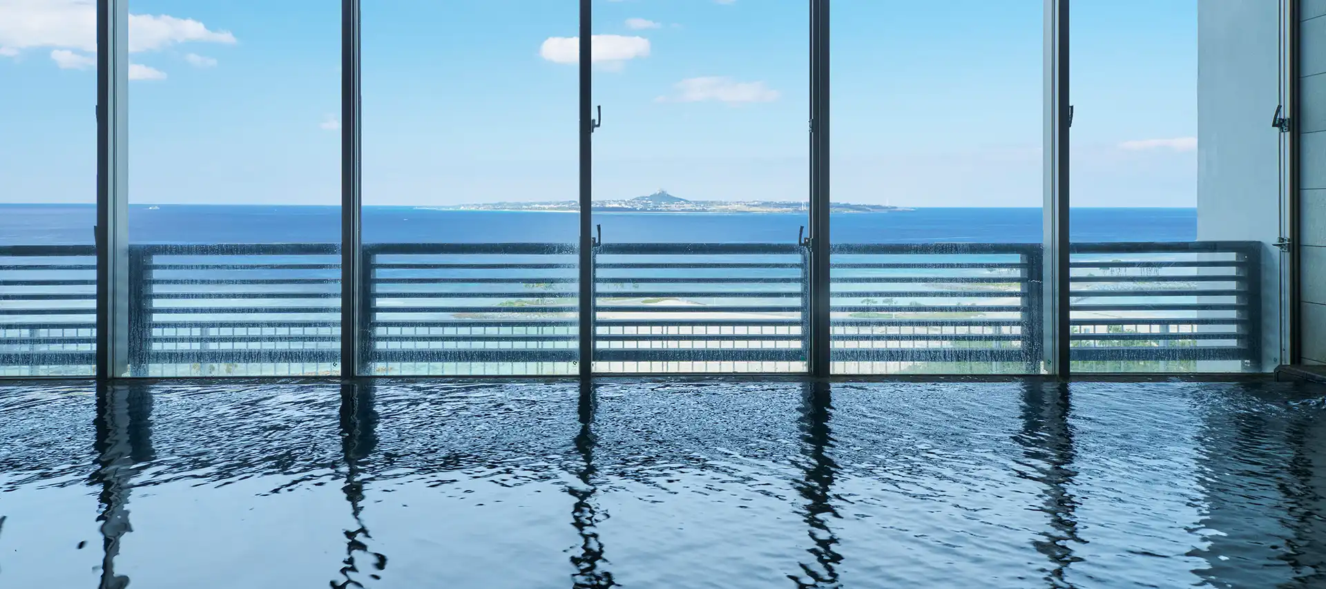 Bain intérieur avec vue sur la mer au Jurassic Onsen Churaumi no Yu