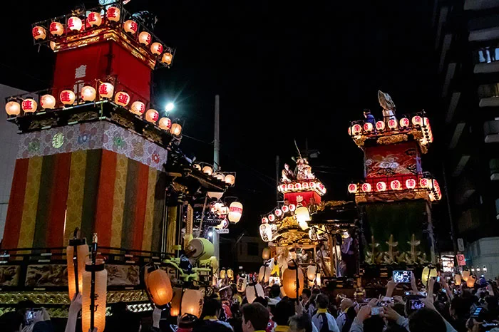 Chars du Festival de Kawagoe se croisant dans une rue après la tombée de la nuit