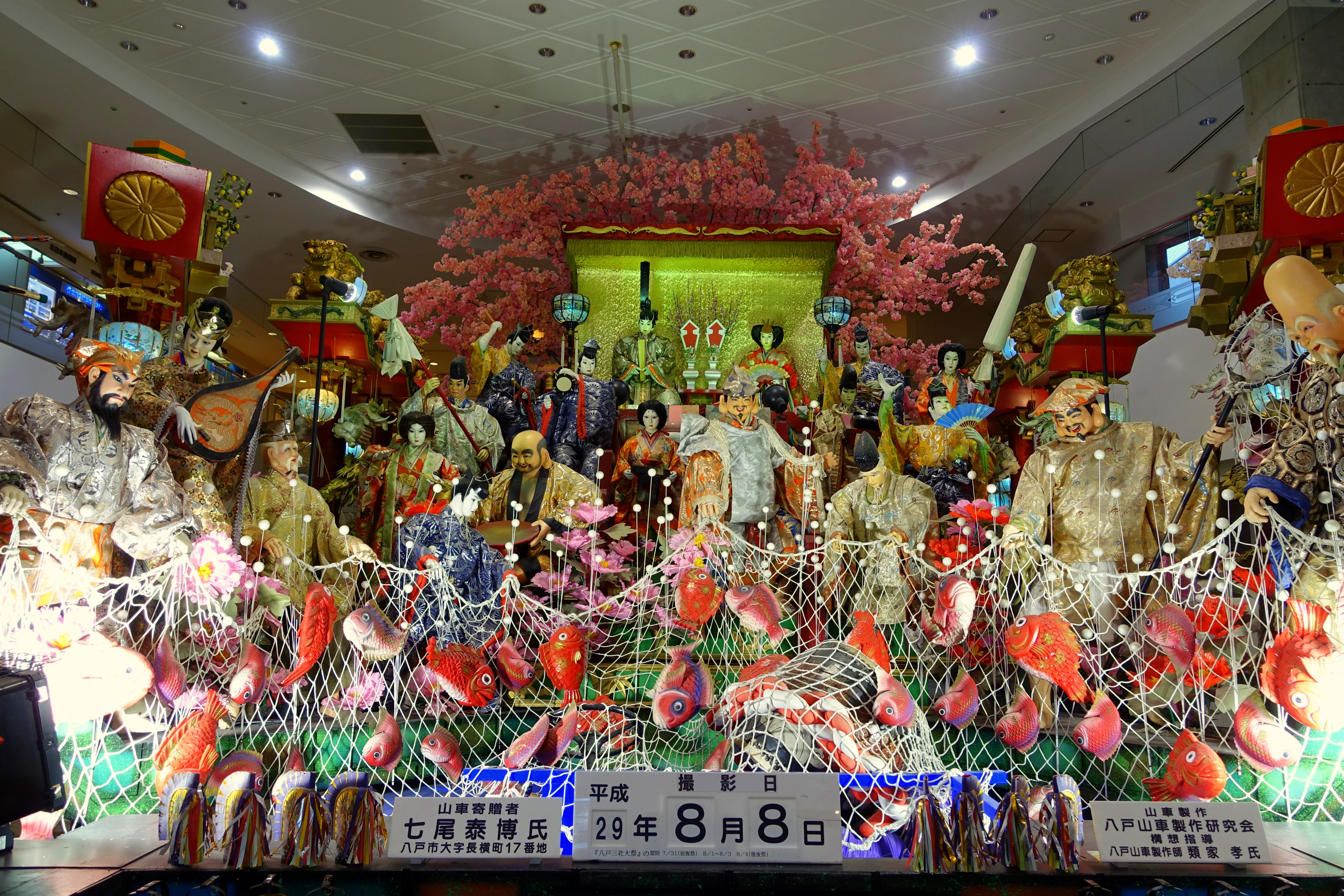 Décoration des personnages sur les chars nocturnes du festival des trois sanctuaires de Hachinohe, avec vue sur les spectateurs, montrant la profondeur après l’allumage des lumières.
